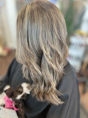 This hair color is a dimensional mix of sandy blonde and soft ash highlights over a light brown base, giving it a natural sun-kissed look