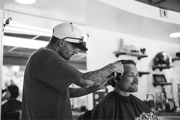 Shop Owner Devan Pearson in the process of a modern mullet.