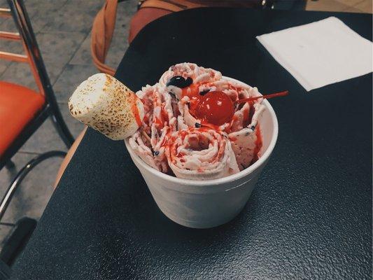 Rolled Ice Cream Topped with Rose Sauce a Toasted Marshmallow and a Cherry