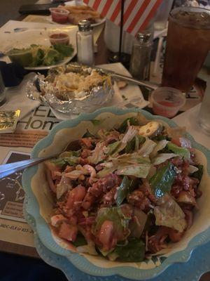 Grilled Chicken salad with a side baked potato.