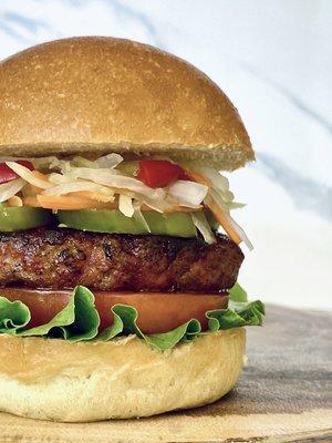 Chori Burger - Grilled Sweet Garlic Chorizo served in Brioche Bun, mayo, lettuce, tomato, jalapeno and pickled green papaya.