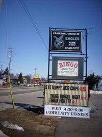 Sign along road in front of building.