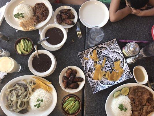 Steak on left lower and ropa vieja on top (a type of she'd need una tomato sauce) black beans avocado and sweet plantains.
