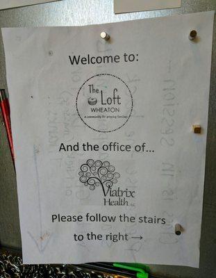 Take the door in the parking lot, and go up the stairs.