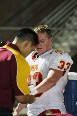 Dr Wu treating an injured Desert Chiefs player on the sidelines