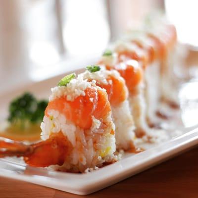 With shrimp tempura, crab and avocado topped with salmon, spicy tare sauce and crunch