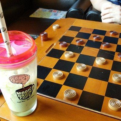 Enjoying an iced matcha latte and a mean game of checkers.