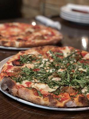 11" DIY pizzas (in focus) Roasted tomato, caramelized onion, feta and arugula.