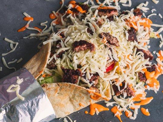 Tandoori Chicken Wrap - Tandoor Fired wrap loaded with tandoori chicken, fresh veggies, drizzled with our signature garlic sauce and lime !