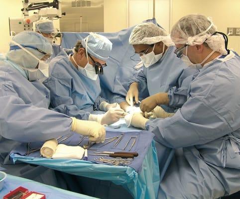 Dr. Burke and Dr Samuel with surgical tech performing surgery.