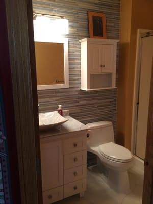 Demo the old bathroom. Installed new tile on floor and back wall. Detached and reset toilet and heat register...