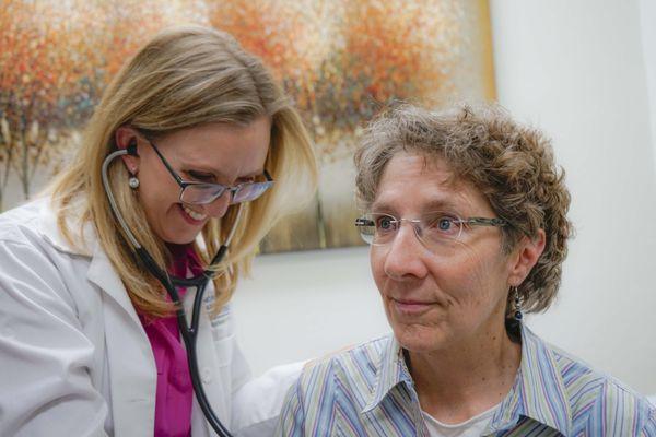 Terry Smith, FNP, checking the heart rate of a patient.