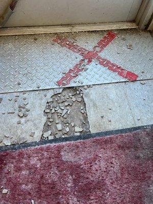 Broken floor tiles. Tripping hazard.