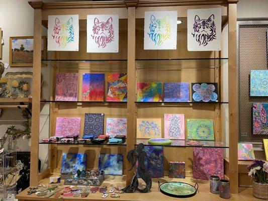 Paintings, prints, custom pottery and intricate rings and bangles draw many customers to gaze in front of these shelves.