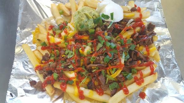 Mexorean Fries - fries w/ colby jack cheese, gogi beef, cilantro, green onions, a scoop of Guacamole, sour cream & sriracha