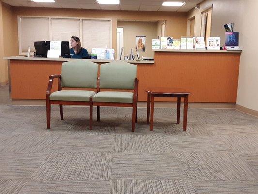 Chastity, greeting clients in spacious waiting room.