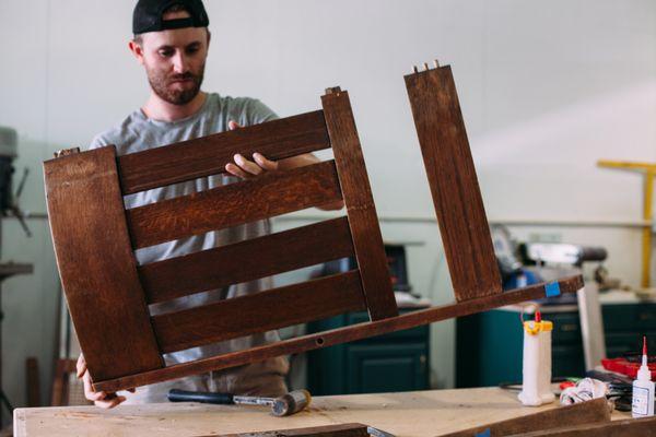 Sam repairing and restoring an antique oak mission style rocker.