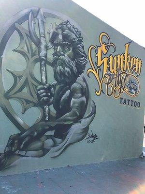 Sunken City Tattoo mural on outside wall of shop.
