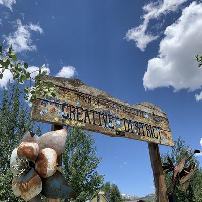 Sign in vicinity of depot, snow-capped mountains in background