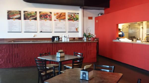 The front counter, a peek into the kitchen, and part of the dining area.