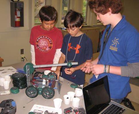 A camp instructor helping a group build their robot.