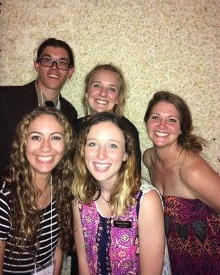 Friends in front of their beautiful white rose wall!