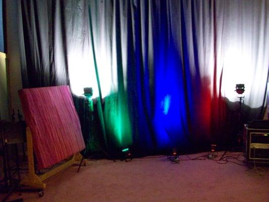 A shot of some backdrop lighting inside the large studio room. There is also a large green screen behind the black curtains