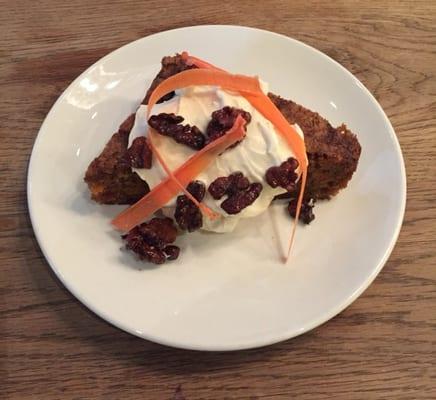 Carrot cake with whipped and cream cheese frosting, sugared walnuts, carrot slices.