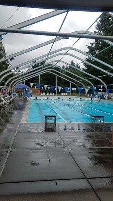 Outdoor swimming pool. Notice it's raining, and the only cover is for the lifeguards. Photo taken in mid-June.