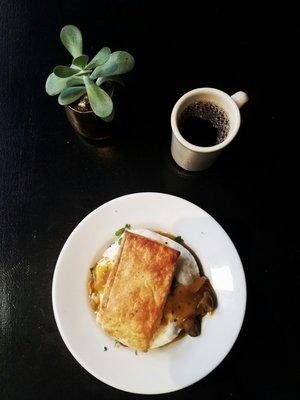Biscuits and mushroom gravy with two over-easy eggs, and a black coffee