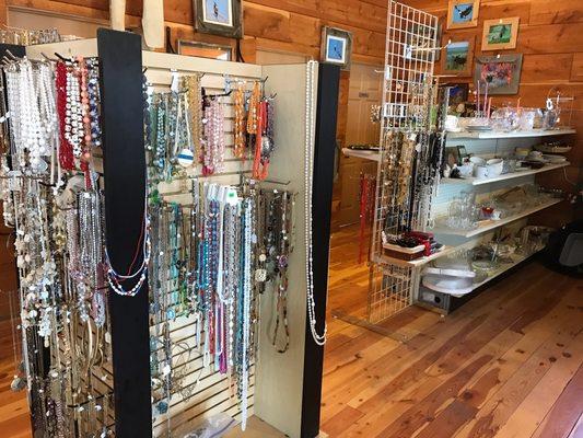 Vintage costume jewelry on rack Antique glassware on shelves