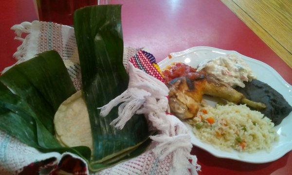 Plato de Gallina with hand patted maize tortillas served hot wrapped in banana leaf & colorful napkin.