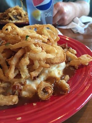 Meatloaf cradled on homemade mashed potatoes, topped with fried onions and gravy.