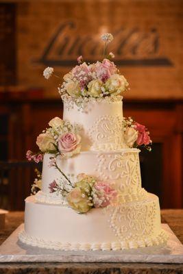 Custom wedding cake: strawberry, green tea, and vanilla chiffon cake with cream filling. Decorations are fresh flowers.
