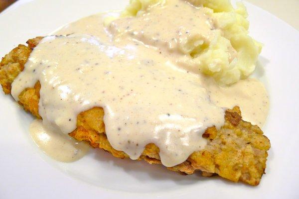 country fried steak smothered in white gravy with mshed potatoes